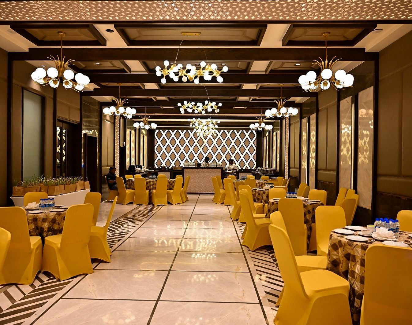 Event space with round tables and chairs arranged, featuring fancy lights hanging from the ceiling at  BluSalzz Residence, Amritsar